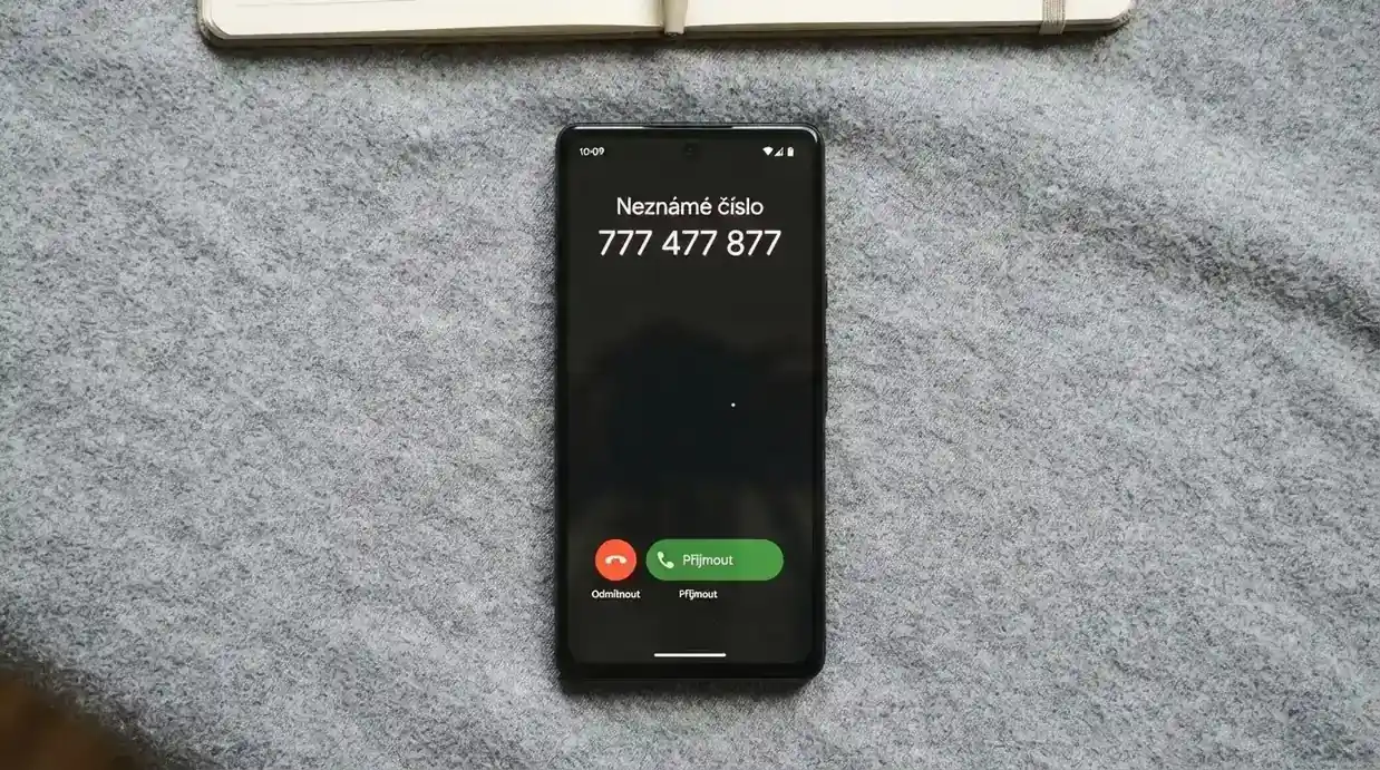 Telefon s vytočeným číslem 777 477 877 na displeji, v pozadí logo Linky pomoci — nonstop spojení s odborníky